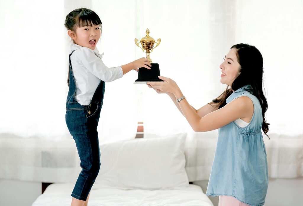 Asian daughter express exciting after get reward as trophy from her mother